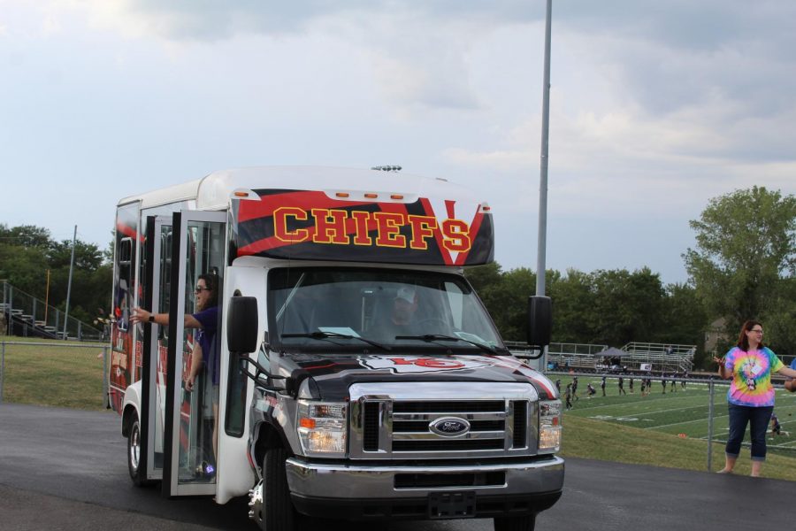 Chiefs bus booms "Red Kingdom" while driving past the football field. 