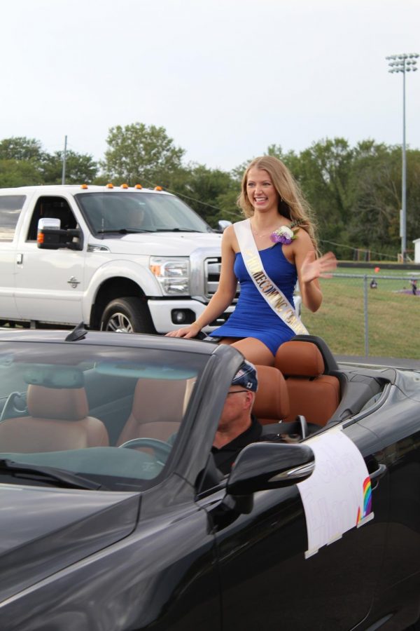 Homecoming candidate Olivia Golden cheeses while waving to those on the parade route. 