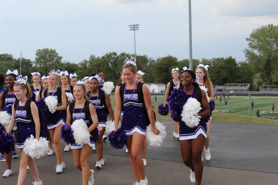 Cheerleaders cheer on the crowd while walking the parade route.