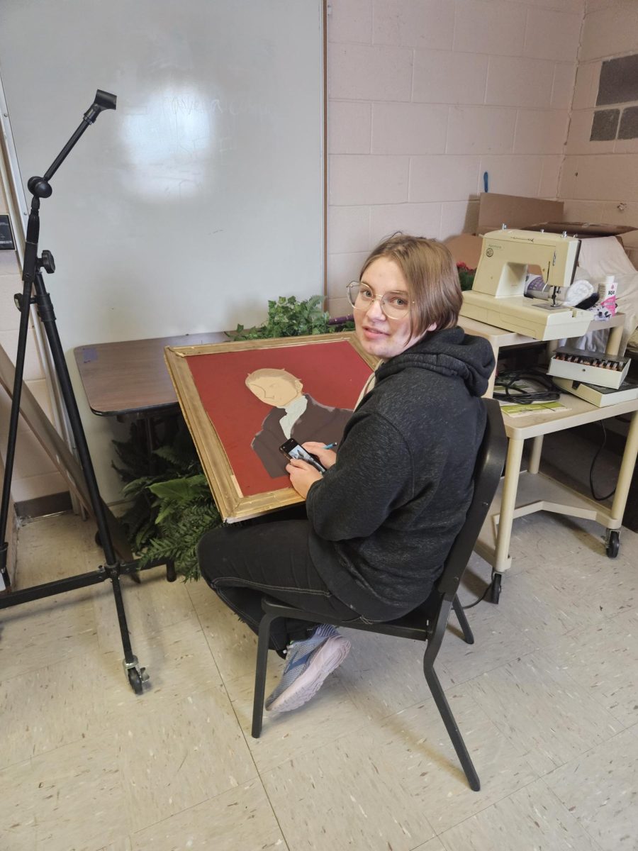 Senior Ilyanna Foehrweiser works on a painting for The Play that Goes Wrong set.